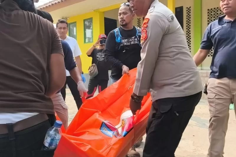 Petugas kepolisian bersama warga saat mengevakuasi jenazah AS (65), marbot Masjid Al-Muhajirin yang tewas bersimbah darah di halaman masjid (Sumber. Istimewa)